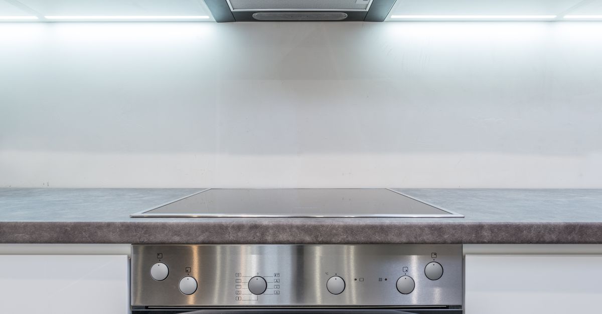 Cooktop de vitrocerâmica limpo e brilhante embutido em uma bancada de cozinha, sem manchas ou riscos visíveis.
