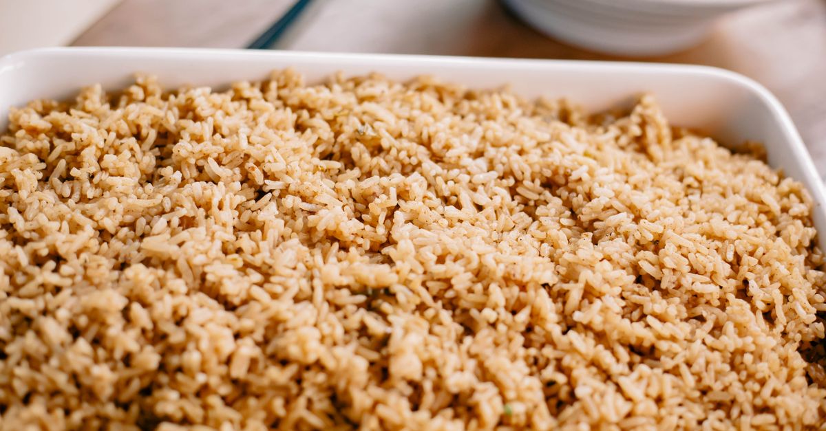 Travessa branca cheia de arroz cozido soltinho visto de perto, com grãos brilhantes e separados.